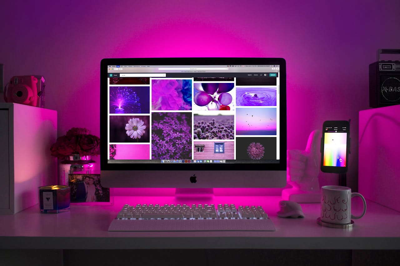 about-us-02 Modern desk setup with neon lighting and a desktop computer displaying colorful images.