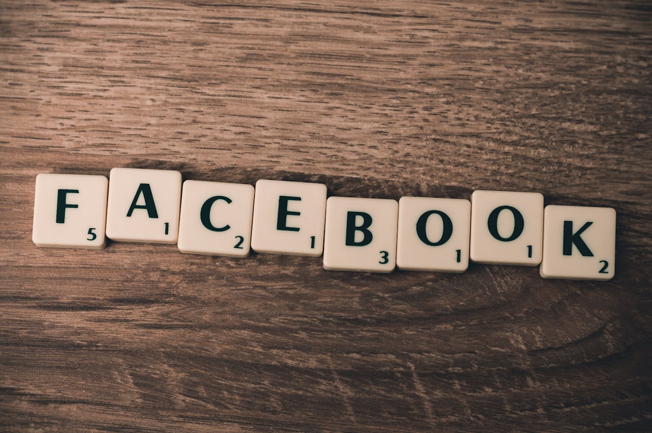 services-02 Scrabble tiles spelling 'Facebook' on a wood background, symbolizing social media.